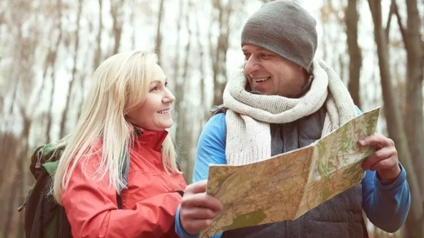 Pareja usando mapa de papel mientras camina. (Foto: Freepik)